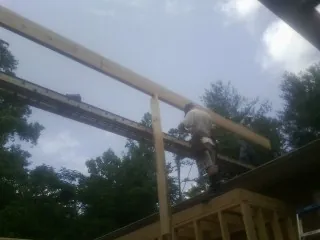Carpenter setting a ridge beam over a new addition frame — Ice Dam Removal by Roofing Brothers in Palm Desert