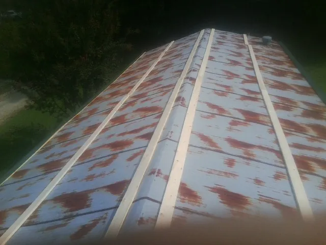 Rusted metal roof panels with new wood purlins before replacement — Storm Damage Roof Repair in Palm Desert by Roofing Brothers