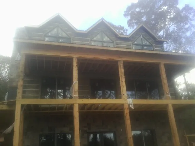Dormers and porch framing on a large log home under construction — Roof Coating work by our crew in Palm Desert